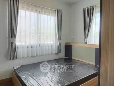 Bright bedroom with large windows and modern bed frame, perfect for cozy living.