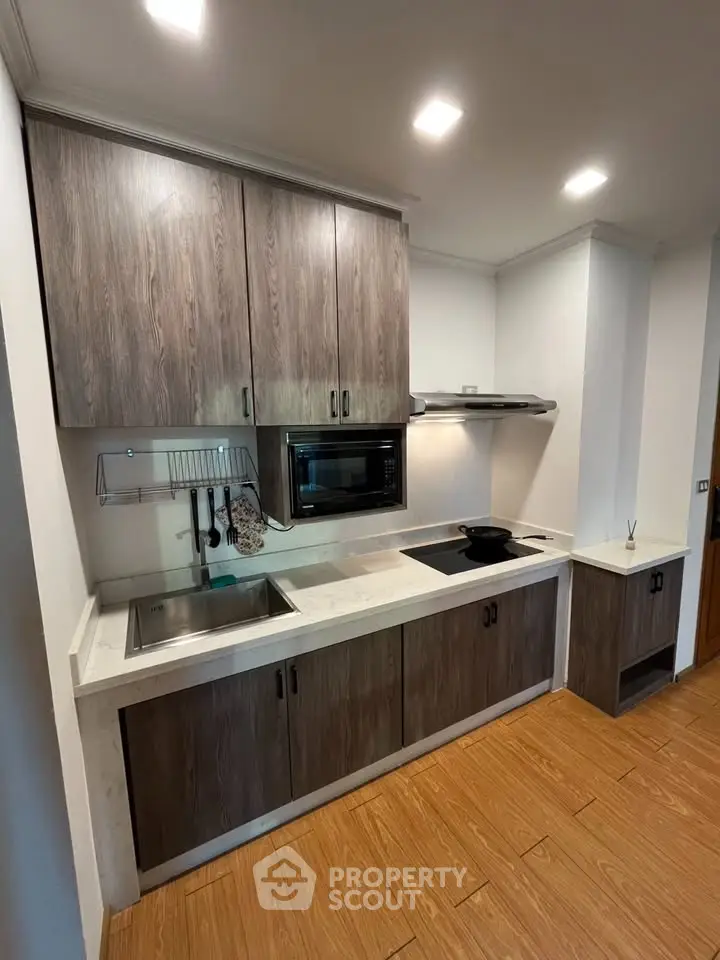 Modern kitchen with sleek cabinets and built-in appliances in a cozy apartment.