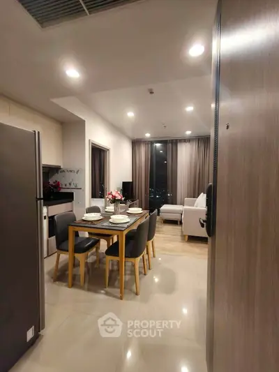 Modern open-plan kitchen and living room with city view, stylish dining set, and cozy seating area.