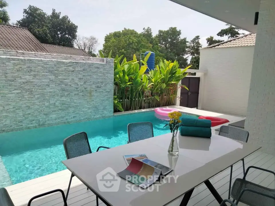 Luxurious poolside patio with modern dining set and lush greenery, perfect for outdoor relaxation.