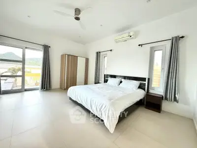 Spacious bedroom with modern furnishings and large windows offering scenic views.