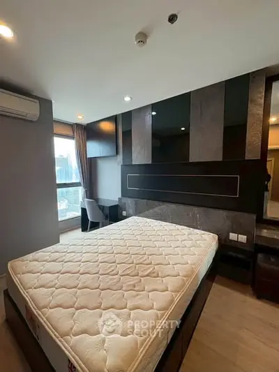 Modern bedroom with city view, featuring a stylish bed and workspace.