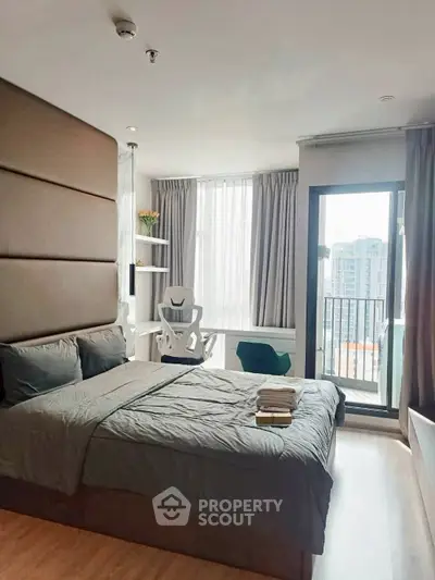 Modern bedroom with balcony and city view, featuring stylish decor and natural light.