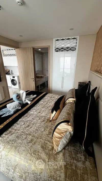 Luxurious bedroom with elegant decor and ensuite bathroom, featuring a washing machine for convenience.