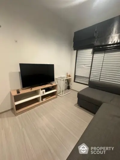 Modern living room with sleek TV setup and stylish gray sofa.