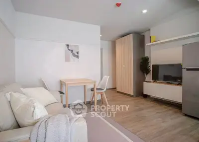 Modern living room with cozy sofa, dining table, and sleek TV setup in stylish apartment.
