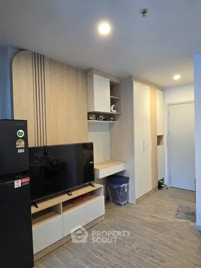Modern living room with sleek wooden cabinetry and flat-screen TV, perfect for contemporary urban living.