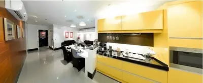 Modern open-layout kitchen with sleek yellow cabinets and spacious living area