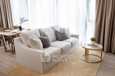 Elegant living room with plush sofa and chic dining area, perfect for modern living.