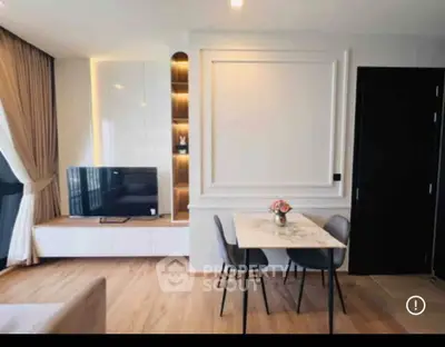Modern living room with stylish decor and natural light, featuring a sleek TV unit and elegant dining area.