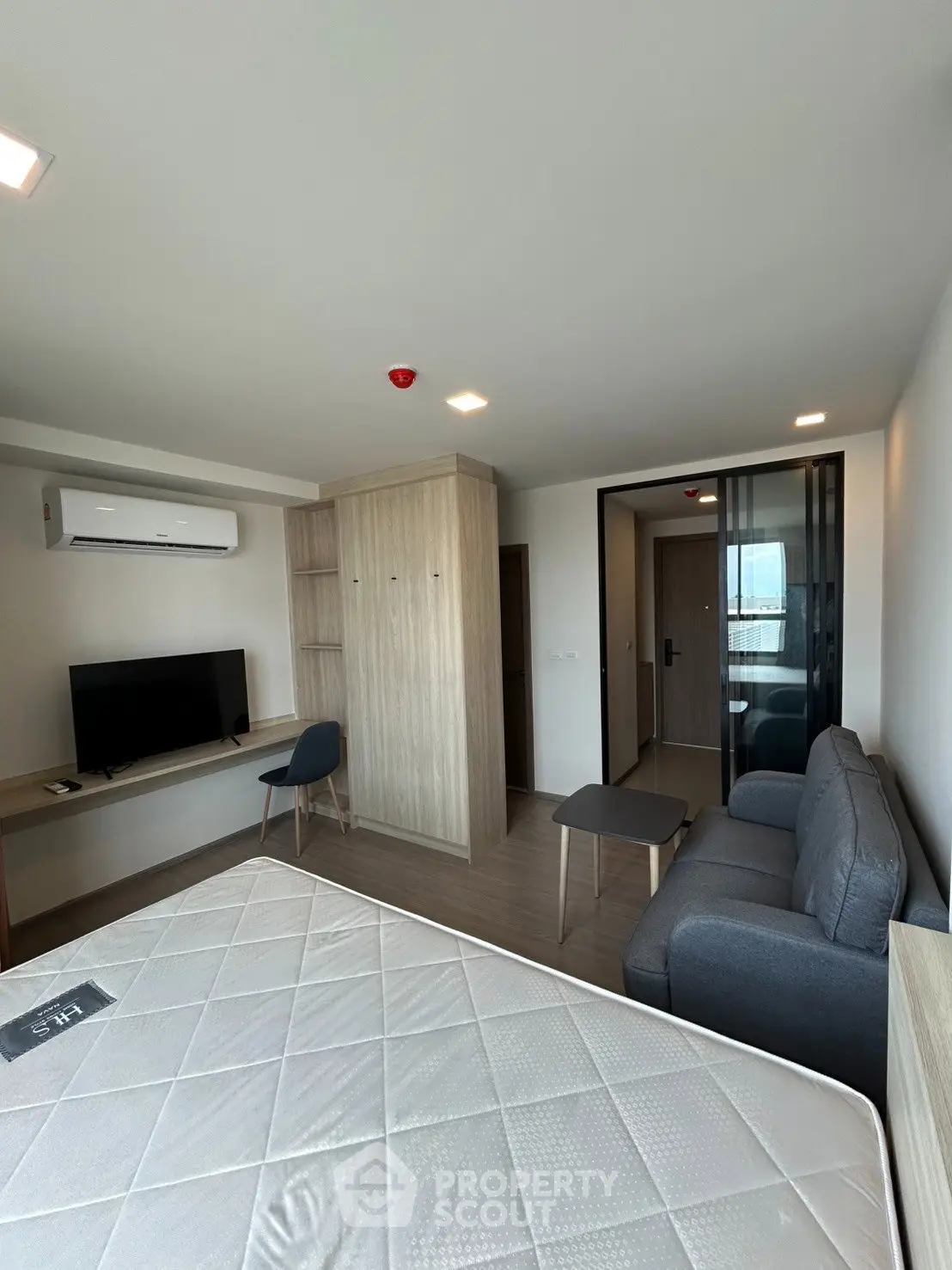 Modern studio apartment with sleek furnishings and ample natural light, featuring a cozy living area and workspace.