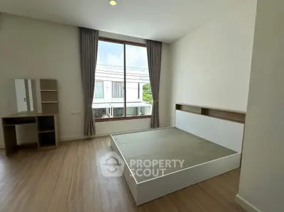 Spacious bedroom with large window and modern minimalist design
