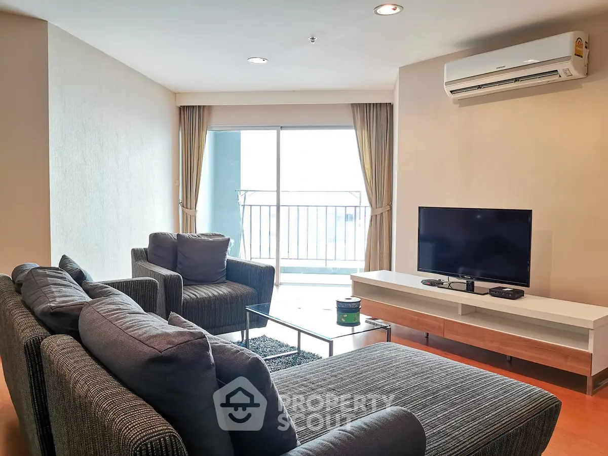 Spacious living room with modern furniture and balcony access in a stylish apartment.