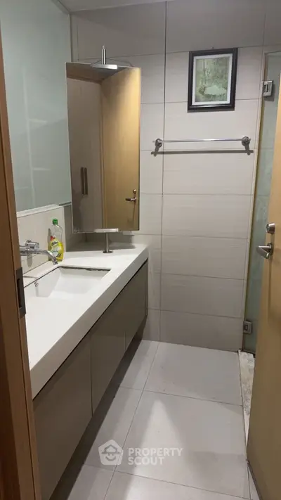 Modern bathroom with sleek vanity and wall-mounted mirror in a contemporary home.