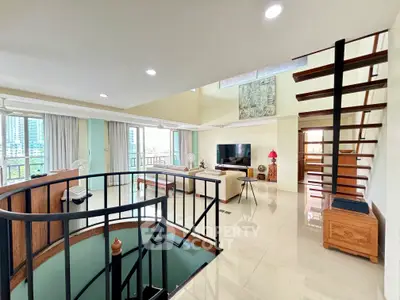 Spacious living room with modern staircase and city view, perfect for urban living.