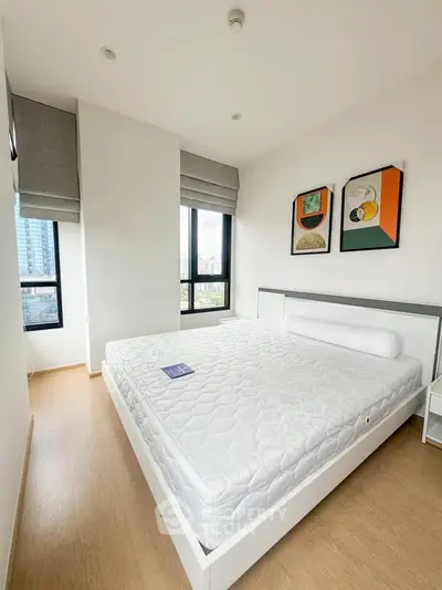 Bright and modern bedroom with large windows and stylish decor in a high-rise apartment.