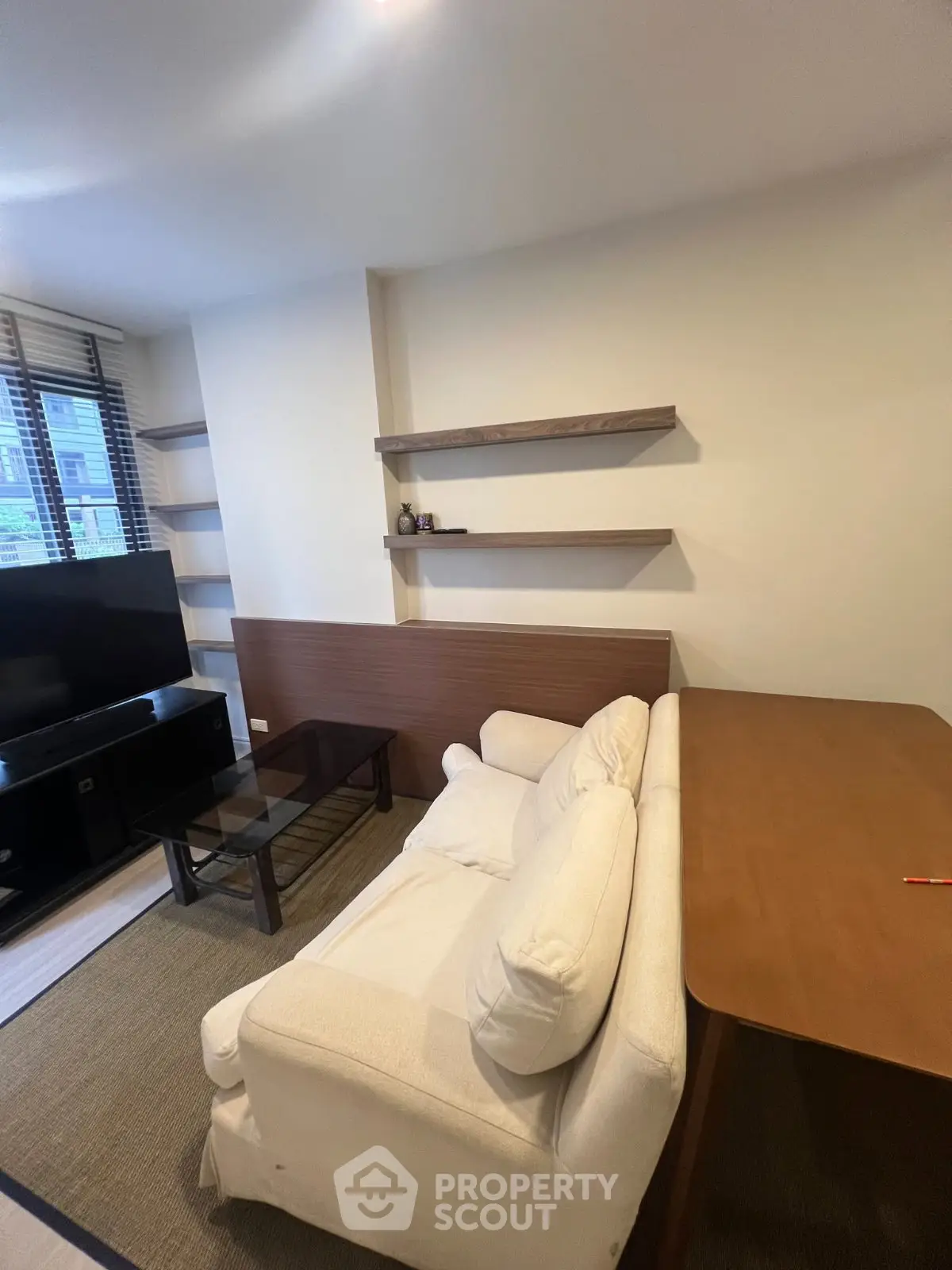 Cozy living room with modern shelves and comfortable sofa in a stylish apartment.