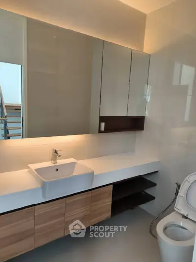 Modern bathroom with sleek vanity and large mirror in luxury home