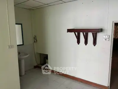 Minimalist interior space with wall-mounted shelf and sink, ideal for creative renovation.