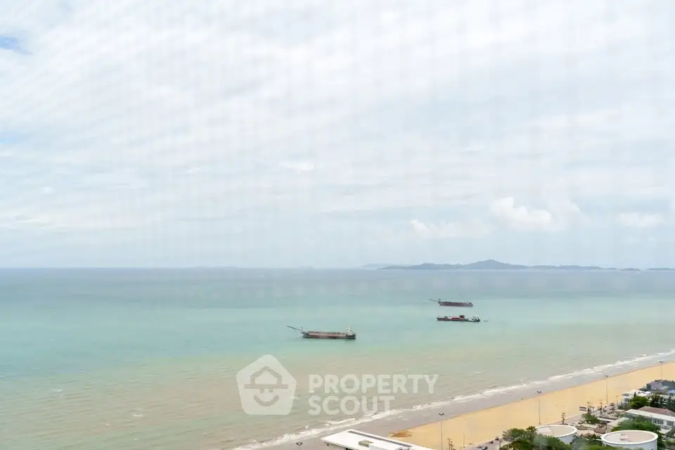 Stunning ocean view from high-rise building overlooking serene beach and distant islands.