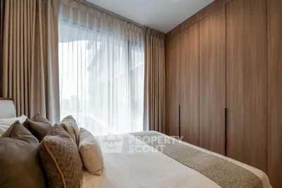 Elegant bedroom with floor-to-ceiling windows and stylish wooden wardrobe