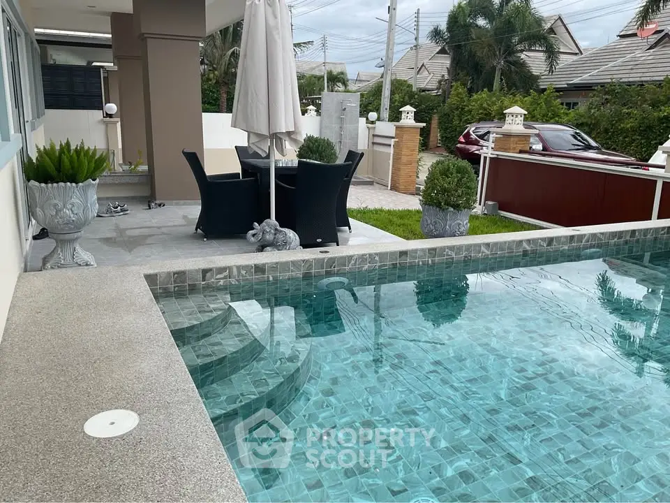 Luxurious outdoor pool area with elegant seating and lush greenery, perfect for relaxation and entertaining.