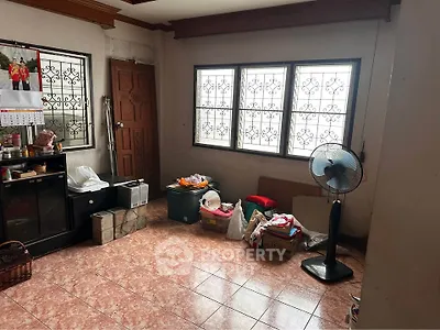 Spacious room with tiled floor, large windows, and ceiling fan, ideal for versatile living space.