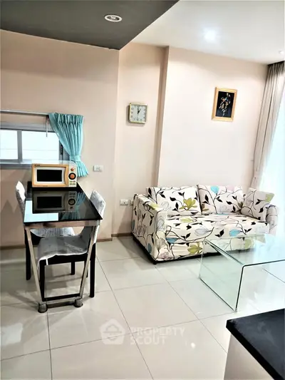 Charming living room with floral sofa and modern dining area in cozy apartment.