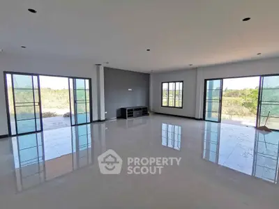 Spacious modern living room with large windows and natural light