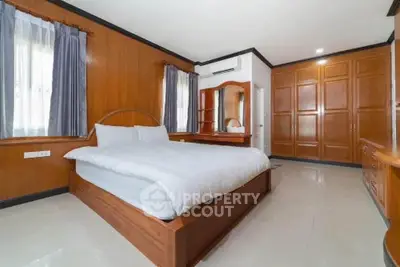 Spacious bedroom with wooden accents and large wardrobe in modern home