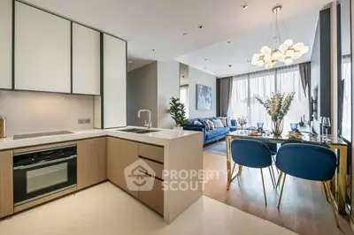 Modern open-plan kitchen and living room with stylish decor and natural light.