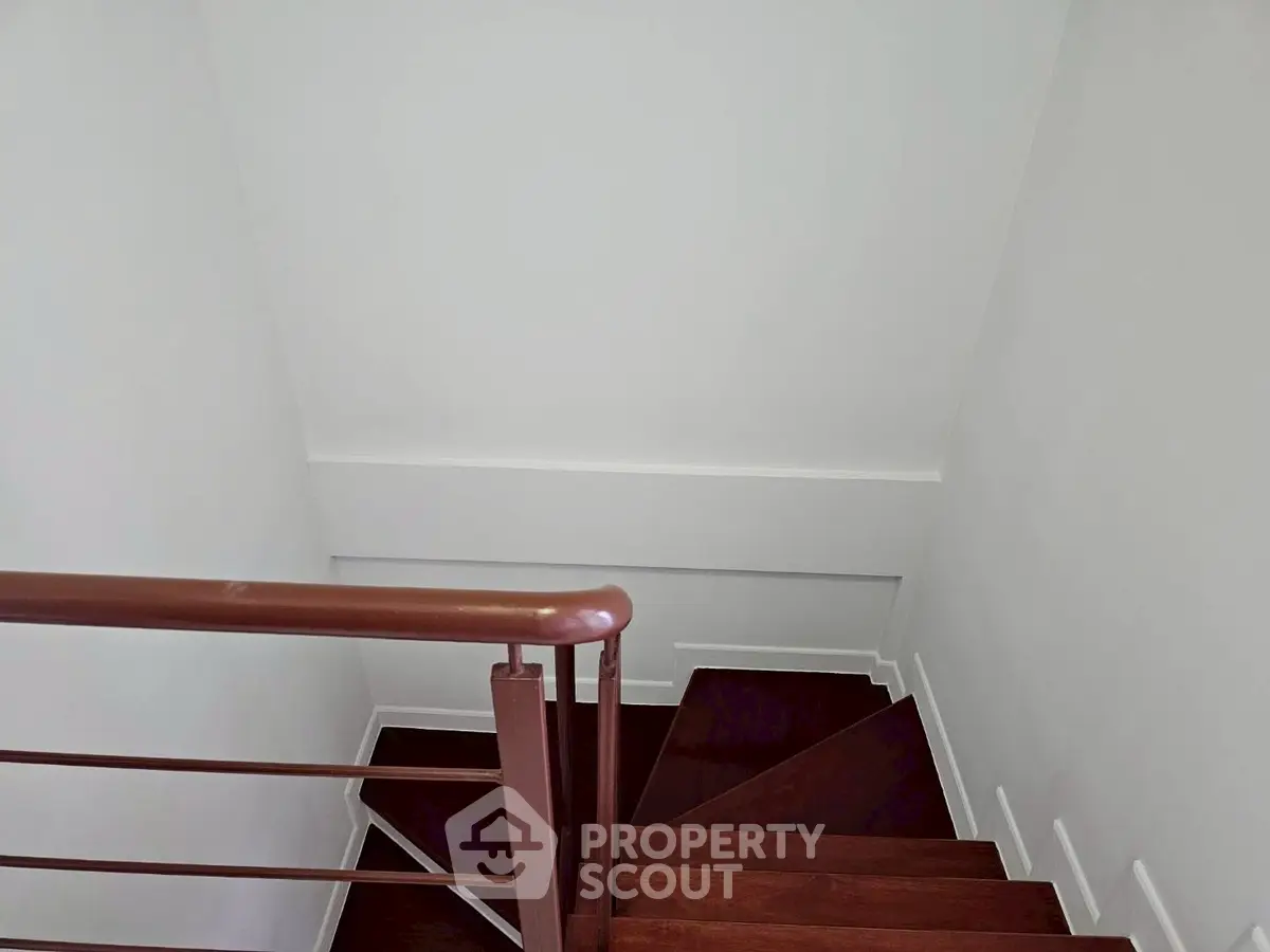 Modern staircase with sleek wooden steps and minimalist railing design