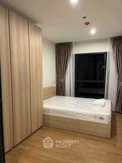 Modern bedroom with wooden flooring and large wardrobe in a stylish apartment.