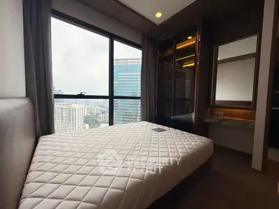 Modern bedroom with city view, featuring a comfortable bed and stylish decor.