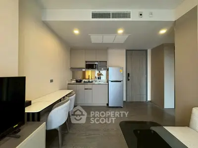 Modern apartment interior with open kitchen and stylish living area, featuring sleek furniture and contemporary design.