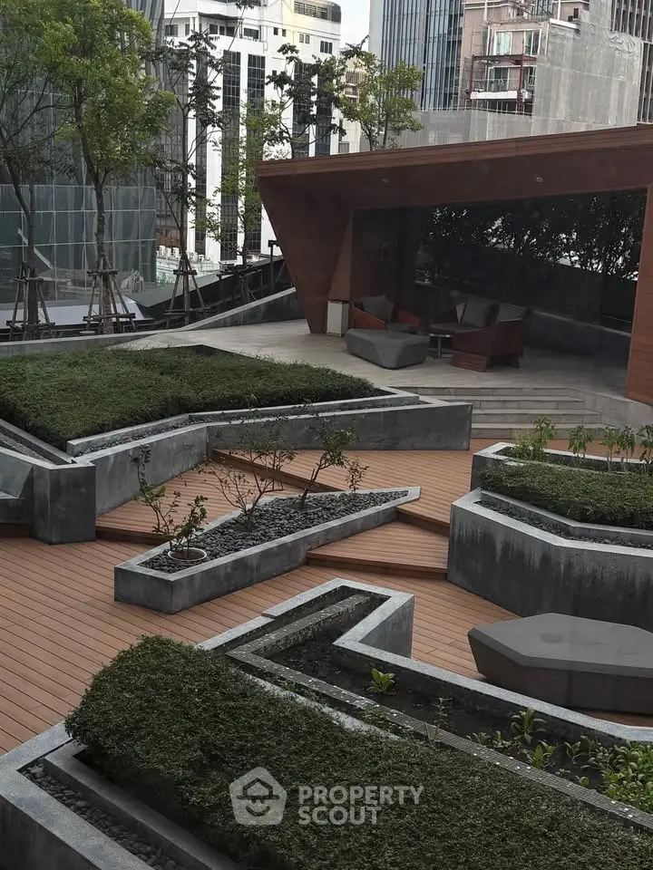 Modern urban rooftop garden with stylish seating area and lush greenery.