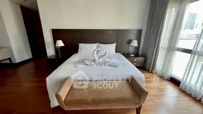 Luxurious bedroom with elegant decor and natural light, featuring a stylish bed and cozy seating area.