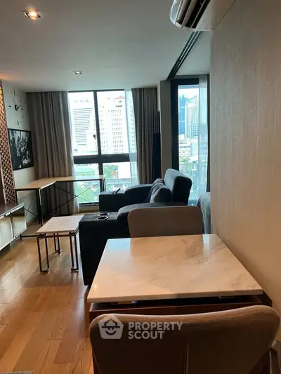 Modern living room with city view, stylish furniture, and wooden flooring in a high-rise apartment.