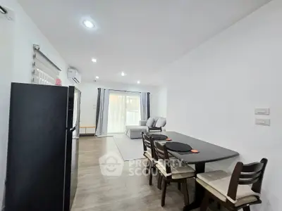 Modern living room with dining area and balcony access, featuring sleek furniture and bright lighting.
