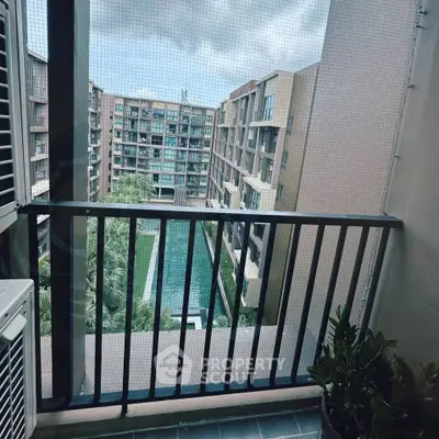 Modern apartment balcony with pool view in urban setting