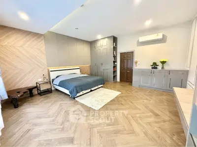 Spacious modern bedroom with stylish wood flooring and built-in storage