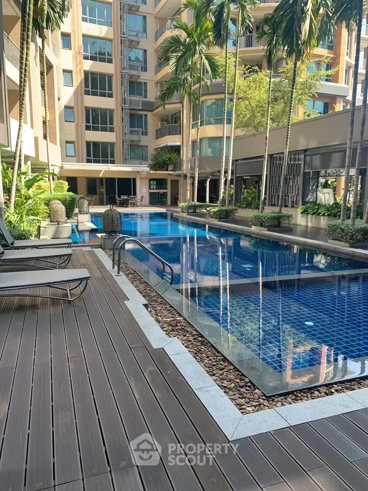 Luxurious condominium pool area with lush greenery and modern design