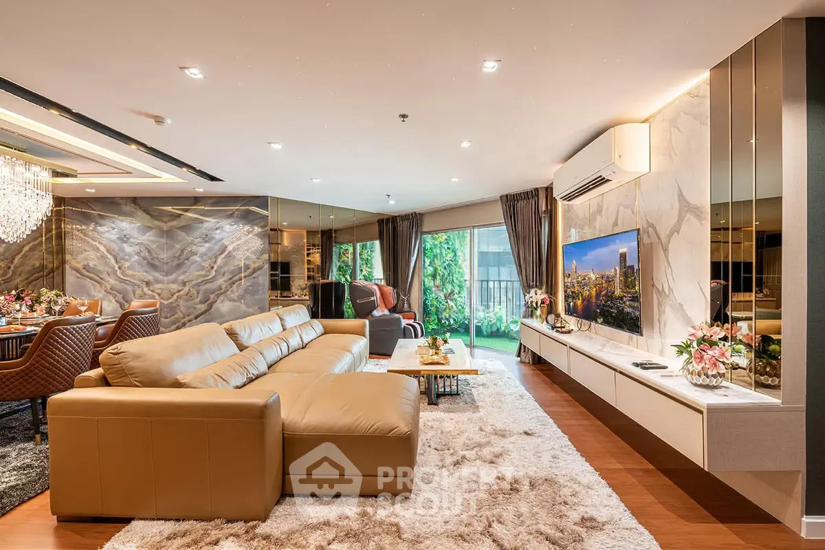 Luxurious living room with elegant decor, spacious seating, and a stunning view of greenery through large windows.