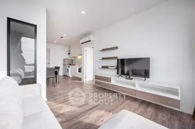 Modern open-plan living room with sleek furniture and integrated kitchen appliances.