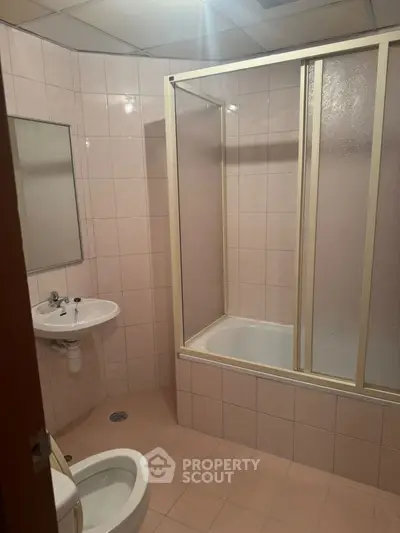 Spacious bathroom with bathtub and tiled walls, ideal for modern living.