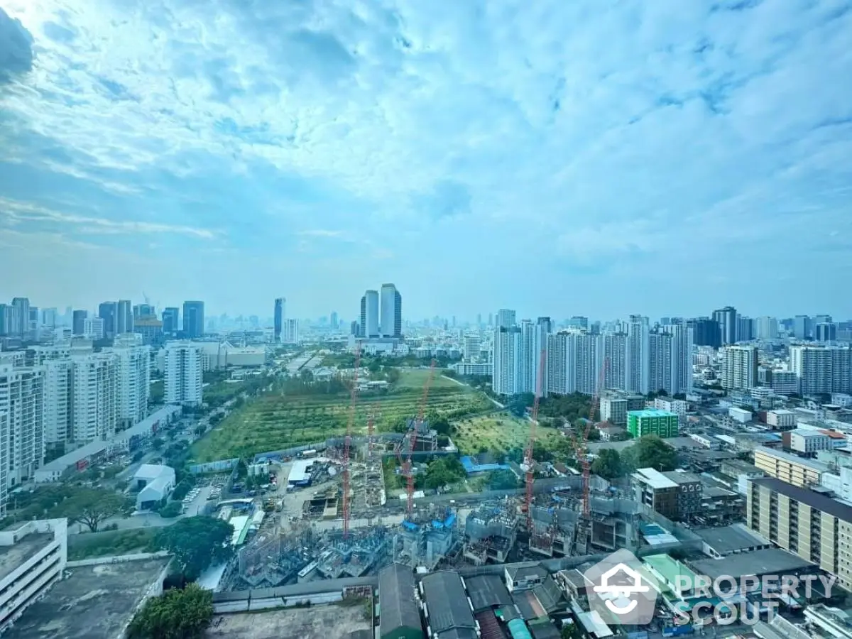 Stunning cityscape view from high-rise building showcasing urban skyline and construction site.