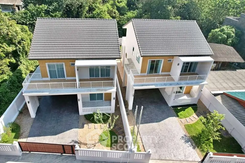 Modern twin houses with spacious driveways and lush greenery in a serene neighborhood.