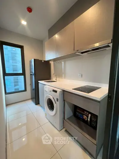 Modern kitchen with washing machine and sleek appliances in a compact layout