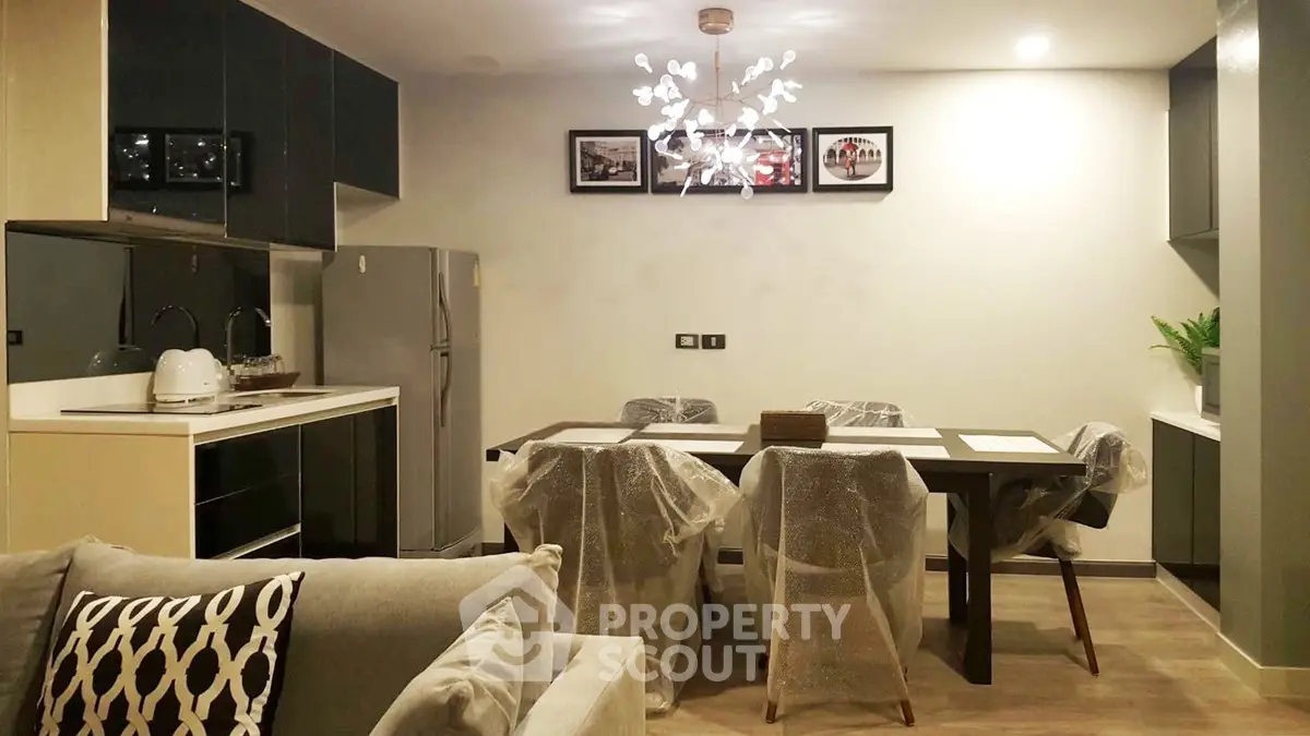 Modern kitchen and dining area with stylish lighting and sleek appliances.