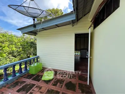 Charming balcony with lush greenery and open door leading inside